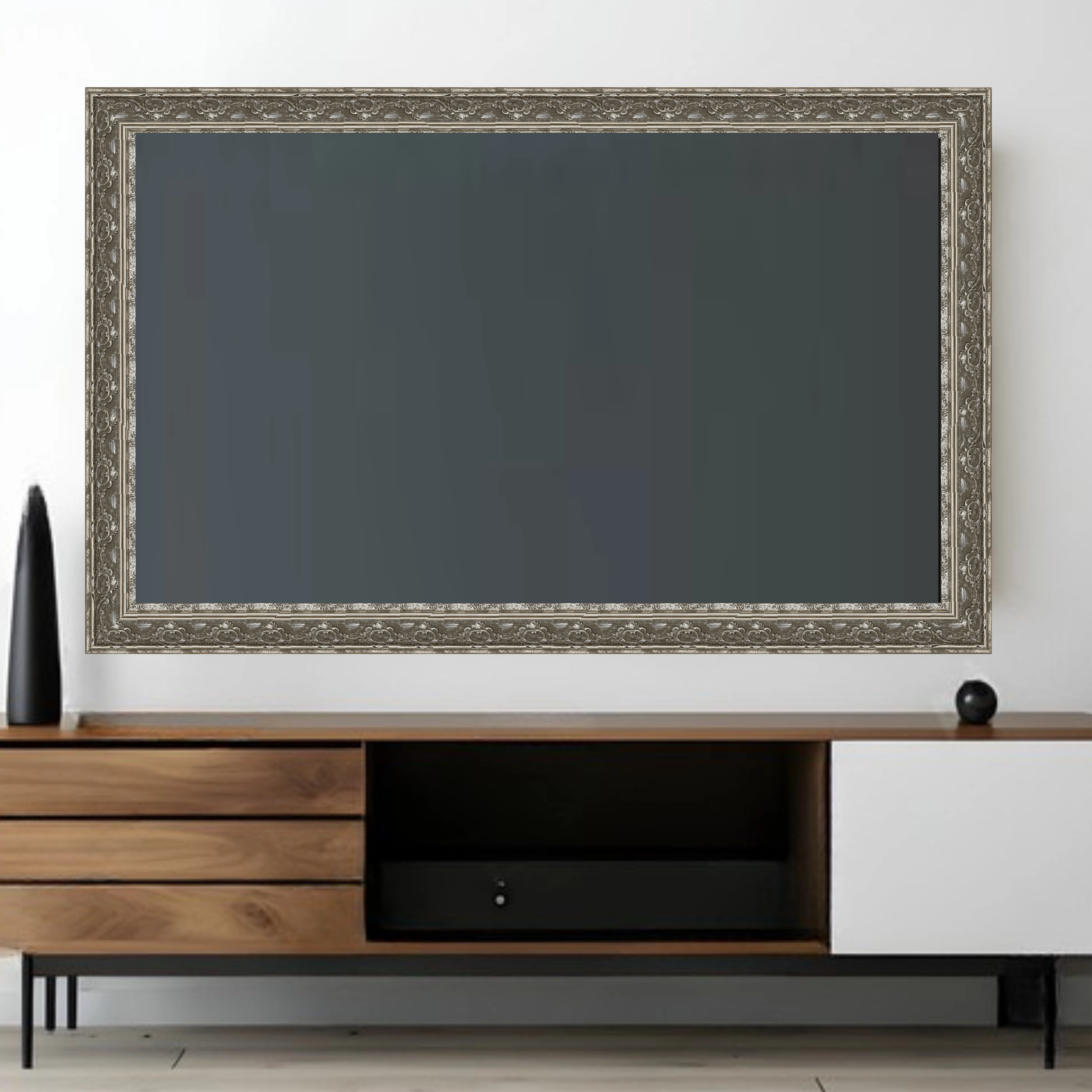 ornate-silver-tv-frame-mounted-on-wall Large ornate silver TV frame mounted on a wall above a modern media console